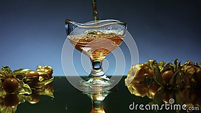 Close up of pouring apple juice into the glass standing on glass surface table. Stock clip. Berries on the table Stock Photo