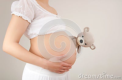 Close up on pregnant belly with toy. Stock Photo
