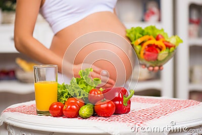 Close-up of a pregnant belly. Women's Health, fortified food. Fresh vegetables, diet and figure Stock Photo