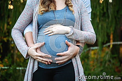 Close up of pregnant couple with hands on belly Stock Photo