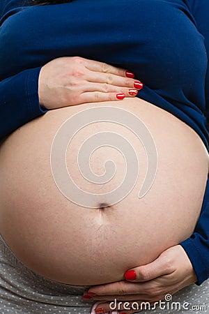 Close-up of pregnant woman grabbing belly Stock Photo