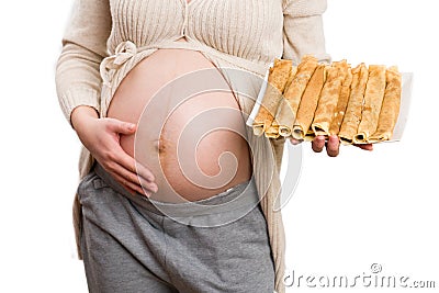 Close-up of pregnant woman grabbing belly and holding plate Stock Photo