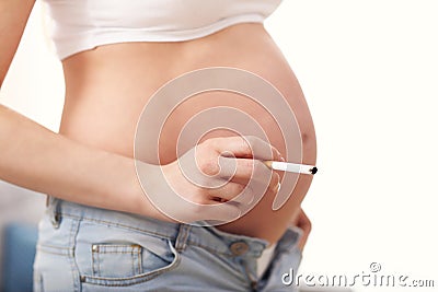 Close up of pregnant woman smoking cigarette at home Stock Photo