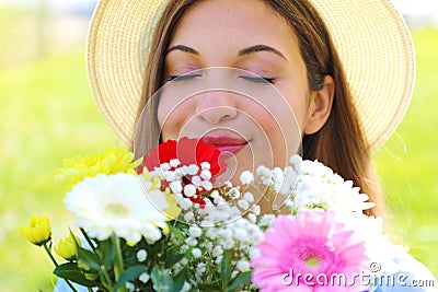Close up of pretty girl smells and appreciates the scent of a bouquet of flowers just received Stock Photo