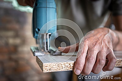 Close-up process of cutting wood board with jigsaw Stock Photo