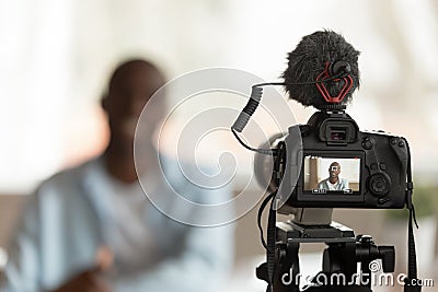 Close up professional camera filming young smiling african american speaker. Stock Photo