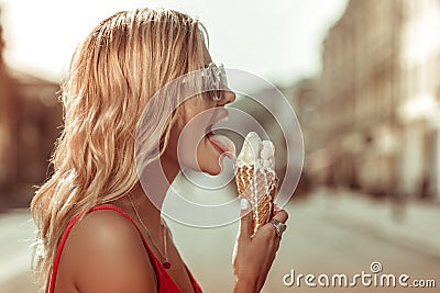Close-up profile portrait of beautiful female leaking melting tasty ice-cream Stock Photo