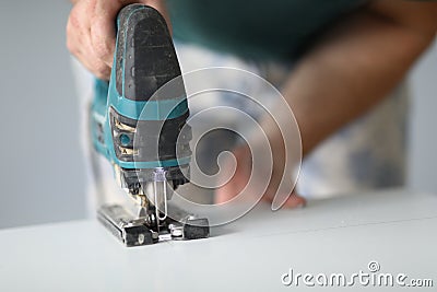 Close-up of qualified worker using electrical instrument for work with wood Stock Photo
