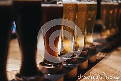Close up of a rack of different kinds of beers, dark to light, on a table. Stock Photo