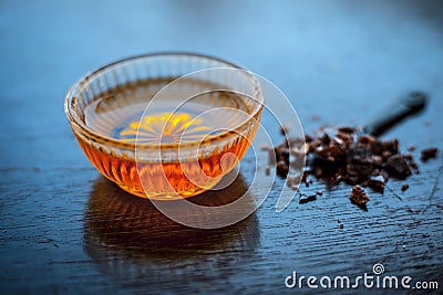 Close up of raw honey in a glass bowl on wooden surface along with powdered rock slat in a black colored spoon.Helps in getting go Stock Photo