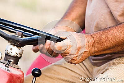 Close Up Of Real Worker Hands with Tractor Steering Wheel Stock Photo
