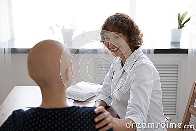 Close up rear view doctor supporting hairless woman at meeting Stock Photo