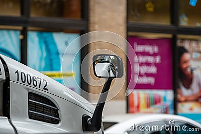 Close-up of a rear-view mirror of a truck on a defocused city background Editorial Stock Photo