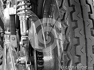 Close up rear view of a vintage motorcycle with tyre treads wheel spokes drive chain and shiny chrome springs Stock Photo