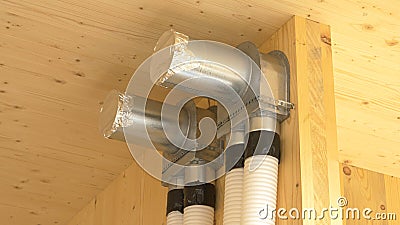 CLOSE UP: Recuperation system exchanger and two tubes run down a hardwood wall. Stock Photo