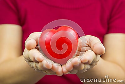 Close up a red heart shape in a hand of women The concept of a physical examination or heart health care Stock Photo