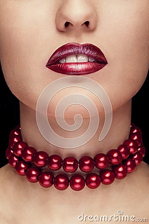 Close up red lips and pearls arround neck on black background Stock Photo