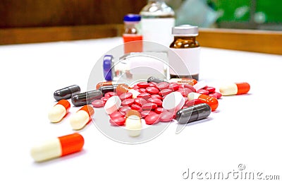 Close up of Red pill medicines and capsule place on white table with ampule blurry background Stock Photo