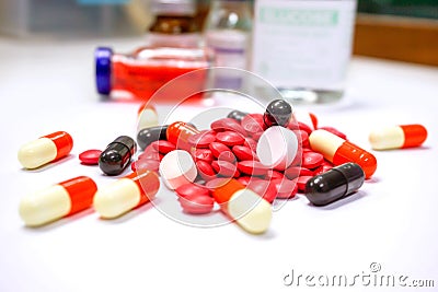 Close up of Red pill medicines and capsule place on white table with ampule blurry background Stock Photo