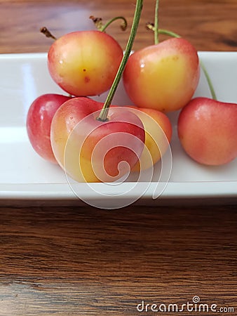 Close up on red and yellow cherries on a white plate Stock Photo