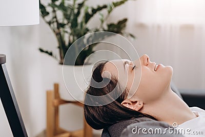 Close up of relaxed pretty young woman lying on comfortable sofa with closed eyes, daydreaming napping resting or meditating, Stock Photo