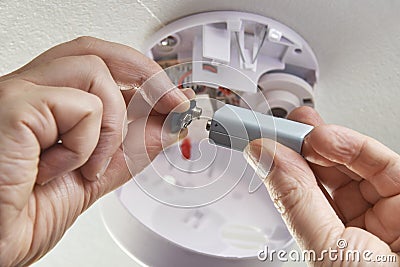 Close Up Of Replacing Battery In Domestic Smoke Alarm Stock Photo