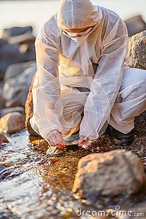 Close-up of researcher collecting water sample at seashore Stock Photo
