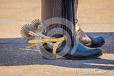 Close up of riding spurs with sharp spikes rowel on authentic western cowboy traditional leather boots on old aged in a Stock Photo