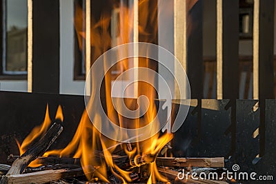 Close-up, roaring fire with blurred flames from wood logs in a stone firepit. Stock Photo