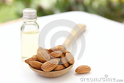 Close up roasted organic brown almond seed with sweet almond oil refine on white floor,copy space Stock Photo