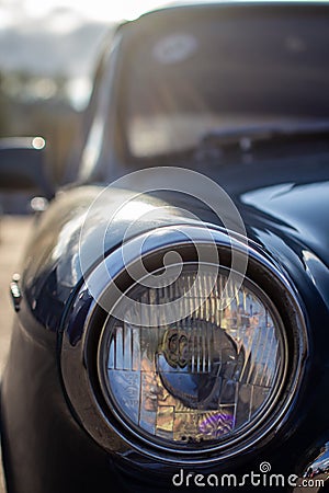 Close-up of a round headlight on an old car. On against the sun Stock Photo