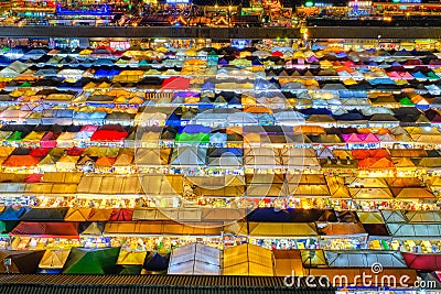 Close-up of rows of colorful market tents and food stalls at night. Stock Photo