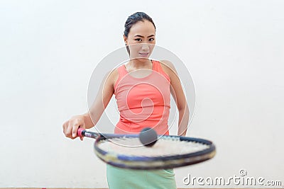 Close-up of a rubber hollow ball on the new squash racket of a fit woman Stock Photo