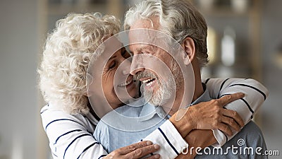 Closeup image elderly wife hug from behind beloved husband Stock Photo