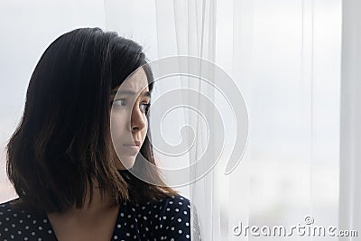 Unhappy young asian woman look in distance mourning Stock Photo