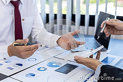 A close-up of the sales manager pressing the white calculator, he is examining the sales figures with management to summarize the Stock Photo