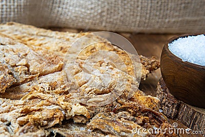 Close-up of salted cod next to grains of salt. Ingredient for fanesca, traditional food from Ecuador in Holy Week Stock Photo