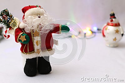 Close up of a Santa Puppet with snowmen in the background with some Festive Christmas Lights Stock Photo