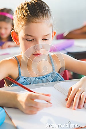 Close-up of schoolkid doing homework in classroom Stock Photo