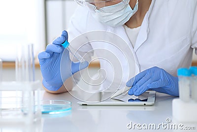 Close up of scientific research hands with clear solution in laboratory Stock Photo