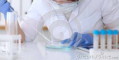 Close up of scientific research hands with clear solution in laboratory Stock Photo