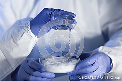 Close up of scientists hands with chemicals in lab Stock Photo