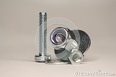 Screws with Nuts and Washer standing and lying on the Ground Stock Photo