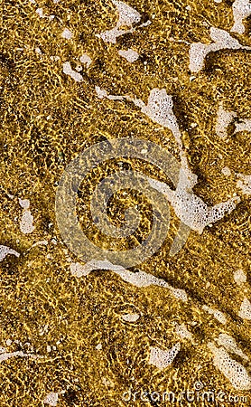 Close-up of the sea coast, clear sea water with shallow waves and a narrow strip of white foam with bubbles washes the Stock Photo