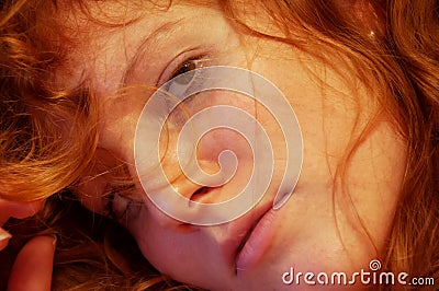 Close-up of a seductive young sexy redhead beautiful sensual woman portrait with long curly hair, indoor Stock Photo