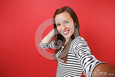 Close up selfie shot of attractive stunning young woman in striped clothes putting hand on head isolated on bright red Stock Photo