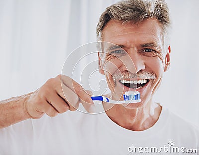 Close up. Senior Man Brushing Teeth in Bathroom. Stock Photo