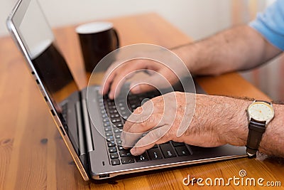 Close up senior man hands working on laptop Stock Photo