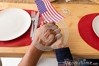 Senior couple praying with hand in hand on dining table at home Stock Photo