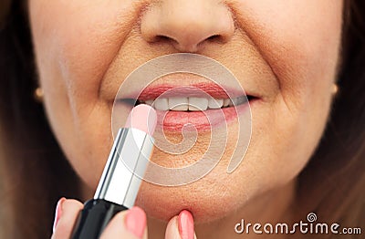 Close up of senior woman applying lipstick Stock Photo